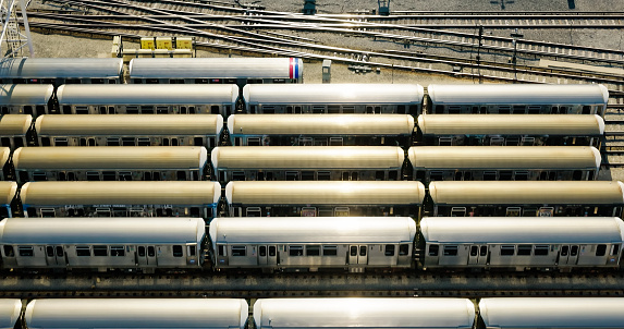 Aerial shot of parked and moving 'L' trains in a rail yard at Howard Station in Chicago, Illinois.