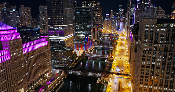 Nighttime aerial shot of downtown Loop skyscrapers and the Merchandise Mart on the banks of the river in Chicago, Illinois at night.