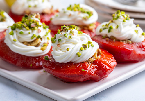 Traditional Turkish style quince dessert. The quince is cooked until soft, sherbet is poured on it, and served with cream and walnuts. It is one of the most popular Turkish desserts.(Ayva Tatlisi)