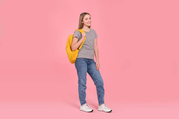 istock Teenage girl with backpack on pink background 1810198708
