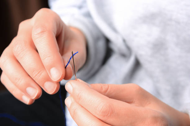 istock Closeup view of woman threading sewing needle 1810221489