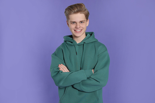 Portrait of teenage boy on purple background