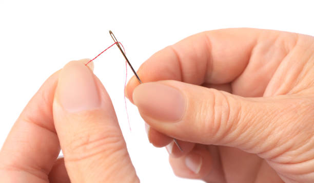 istock Woman threading sewing needle on white background, closeup 1810222542