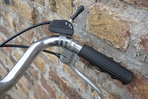 Close-up of the handlebar of an old vintage dutch bike with brake handle and bicycle gear lever for a classical 3-speed gear hub.