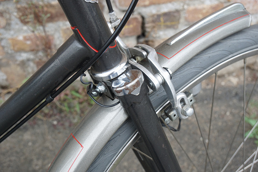close-up of an old vintage dutch bicycle, showing front brake and damaged chrome.