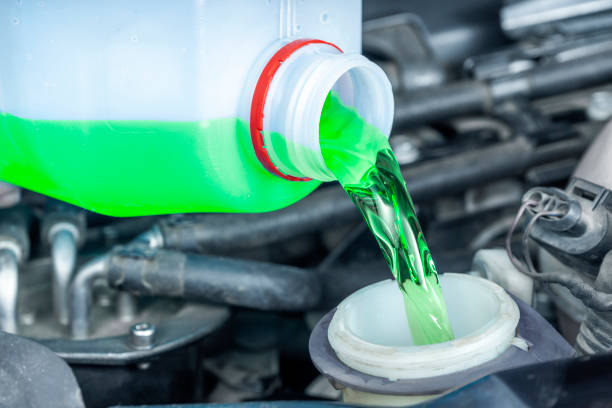 Close-up of pouring green anti-freeze liquid from the bottle to the coolant reservoir. Close-up of pouring green antifreeze liquid from the bottle to the coolant reservoir. Checking levels and periodic maintenance of cars in workshops to avoid overheating and breakdowns. dump radiator stock pictures, royalty-free photos & images