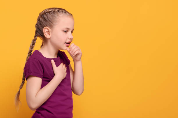 istock Girl coughing on orange background, space for text. Sore throat 1810256171