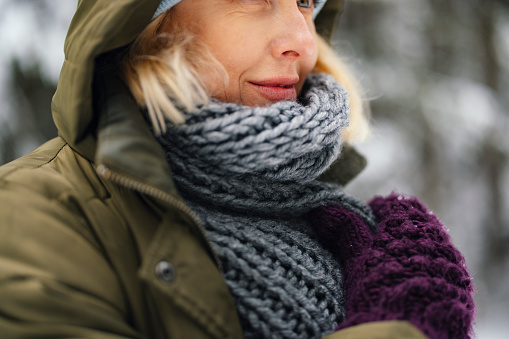 Close up shot of an unrecognizable woman wearing warm winter clothes spending a day outside in the snow.