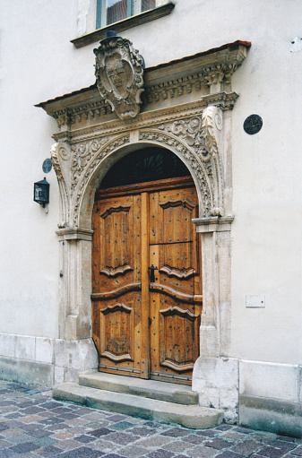 Krakow / Cracow, Malopolska, Poland: old gate with stone frame in renaissance style facing Kanonicza street, attributed to Jan Michałowicz from Urzędów (16th century) - originally built in the 14th century as an episcopal residence for bishop Florian Mokrski.
