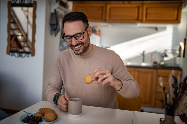 istock A middle-aged white man is drinking coffee and eating a biscuit and jam for breakfast 1810268484