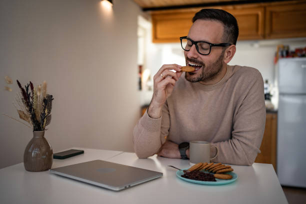 istock A middle-aged white man is drinking coffee and eating a biscuit and jam for breakfast 1810268495