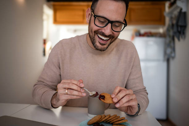 istock A middle-aged white man is drinking coffee and eating a biscuit and jam for breakfast 1810269007