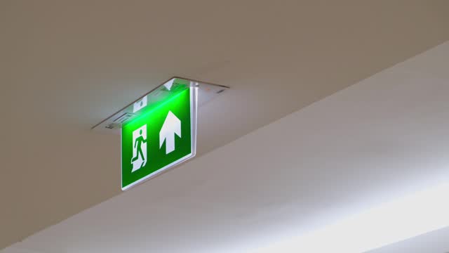 Fire Exit Sign seen fixe on a ceiling of a building in Bangkok, Satey Measure.