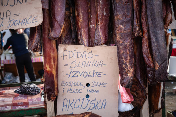 киоск мясника на рынке slaninijada kacarevo, продающий колбасы, копченое и вяленое мясо, а также сушеную свинину, также называемую на сербском языке su - market market stall shopping people стоковые фото и изображения