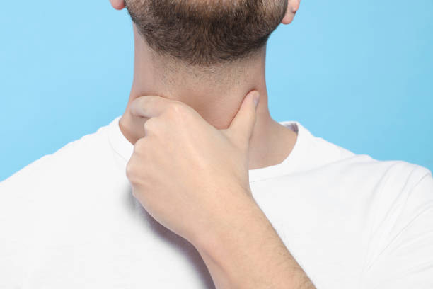 istock Man suffering from sore throat on light blue background, closeup 1810322697