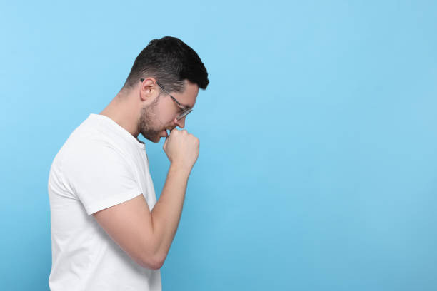 istock Man coughing on light blue background, space for text. Sore throat 1810322714