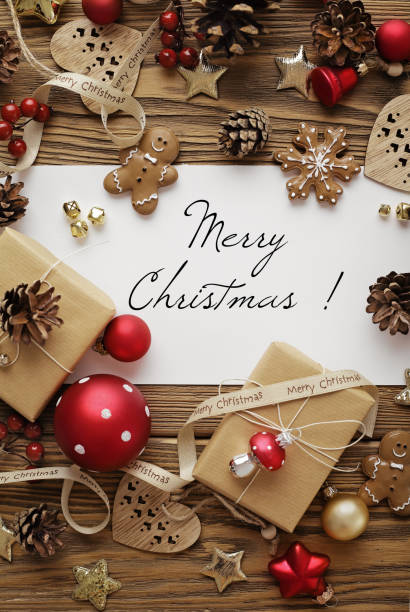 istock greeting card with Christmas tree branches, gingerbread cookies, gift boxes and ornaments on wooden background 1810323769