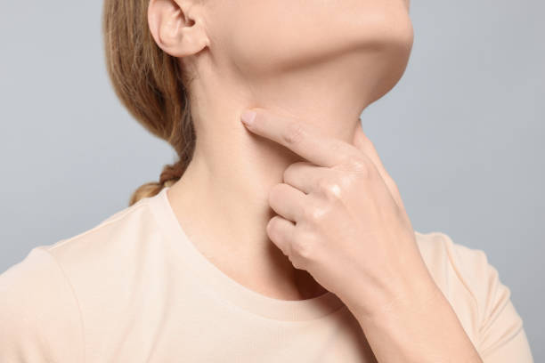 istock Woman suffering from sore throat on light grey background, closeup 1810373406