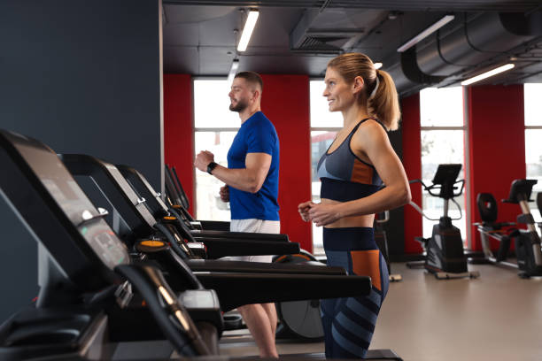 istock Beautiful couple training on treadmills in gym 1810393659