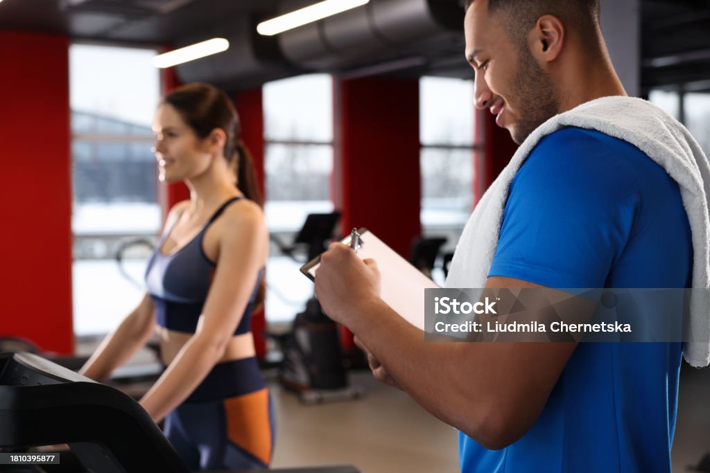 Happy While Exercise Happy Trainer Writing Down Workout Plan While Woman Doing Exercise In ...