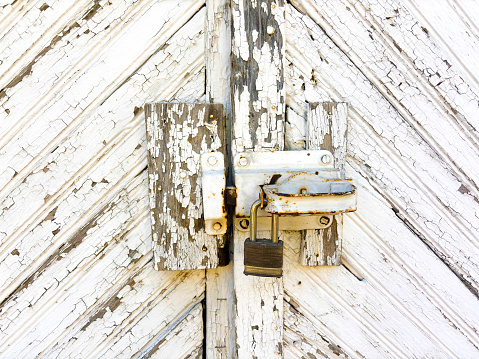 Old wooden window shutters are closed and are located closeup on an old plastered wall for an abstract vintage background