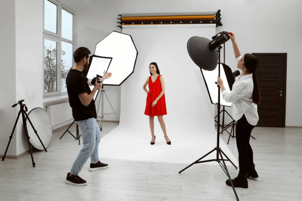 istock Professional photographer and assistant working with beautiful model in modern photo studio 1810420833