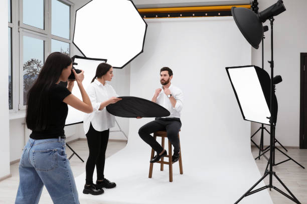istock Professional photographer and assistant working with handsome model in modern photo studio 1810420834
