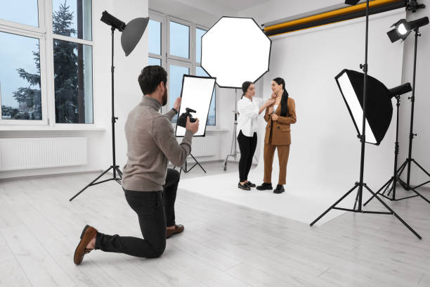 istock Professional photographer and assistant working with beautiful model in modern photo studio 1810421554