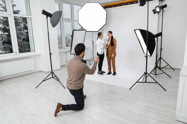 istock Professional photographer and assistant working with beautiful model in modern photo studio 1810421879