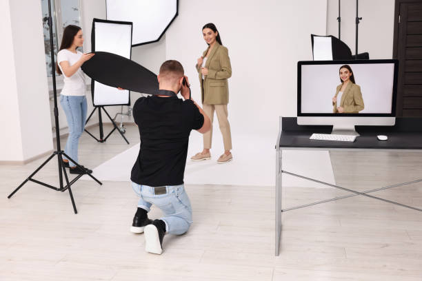 istock Professional photographer and assistant working with beautiful model in modern photo studio 1810422947