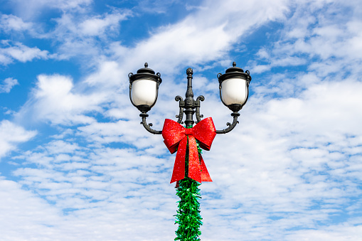 A red bow decoration on a street lamp to celebrate the Christmas holiday.