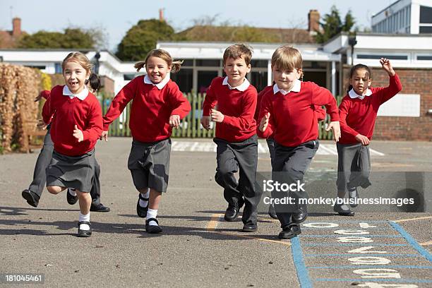 Escola Primária De Alunos De Corrida No Parque Infantil - Fotografias de stock e mais imagens de Edifício escolar