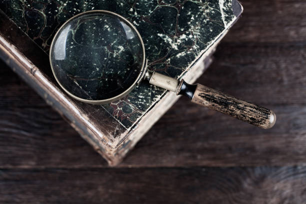 istock Vintage magnifying glass with books on table 1810457374
