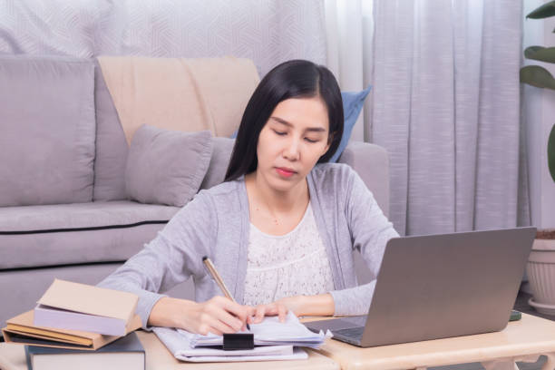 istock Asian happy female working at home calculate bookkeeping for tax declarations using modern technology laptop, well-organized planning financial payment for housing loan, women working paperwork bills 1810459705