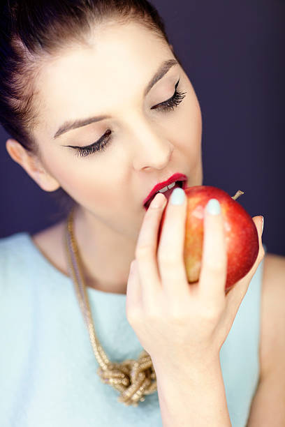 istock Elegant Woman Eating Apple 181047204