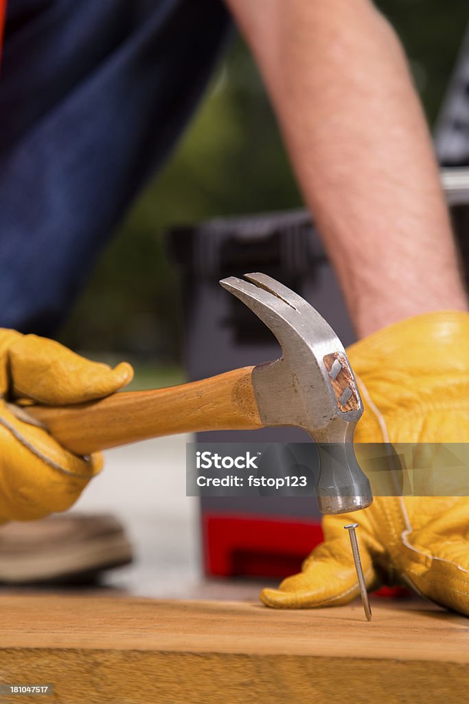 Costruzione: Uomo spinge il chiodo nel legno. Rimodellare lavoro - Foto stock royalty-free di Addetto alla manutenzione