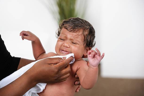 African American kobieta wycieranie Wymiotować z Newborn – zdjęcie