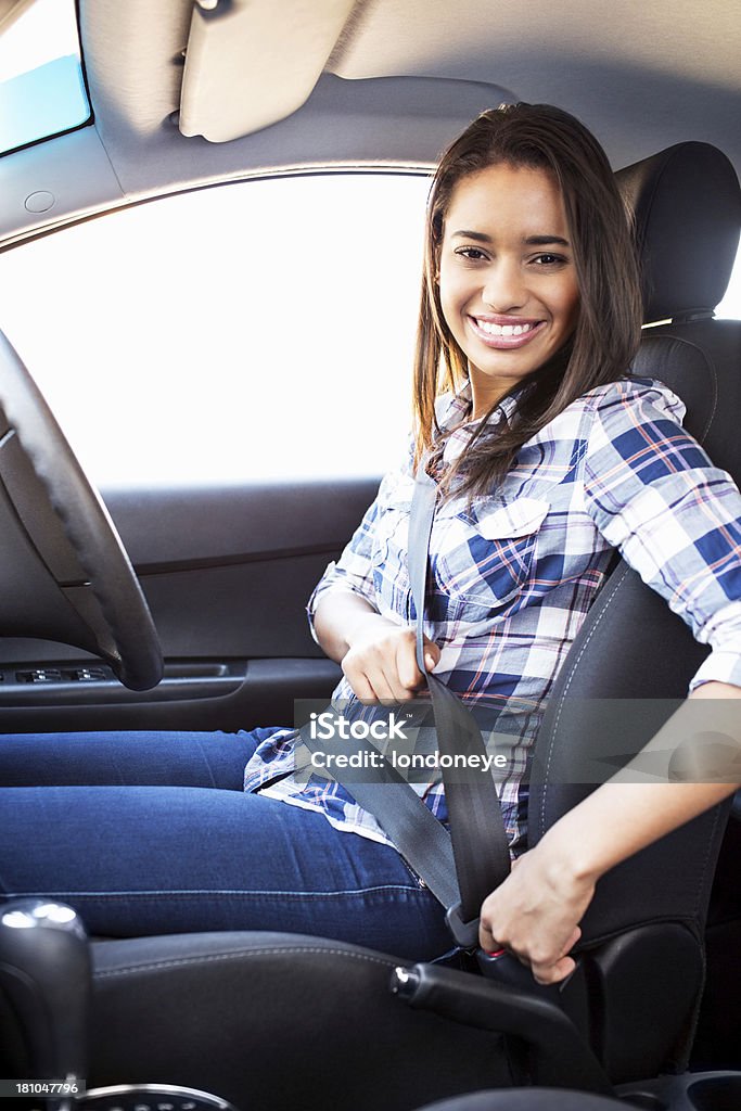 Teenage Girl Fastening Seat Belt In Car Portrait of teenage girl fastening seat belt in car. Vertical shot. Fastening Stock Photo