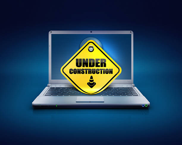 website under construction sign on computers pc computer laptop on a blue background with sticky note showing the under construction words written on screen, Concept of website progress or web development or PC amendments. traffic cone isolated road warning sign three dimensional shape stock pictures, royalty-free photos & images