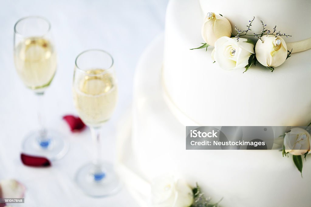 クローズアップのウェディングケーキとシャンパン Flutes のテーブル - ウェディングケーキのロイヤリティフリーストックフォト