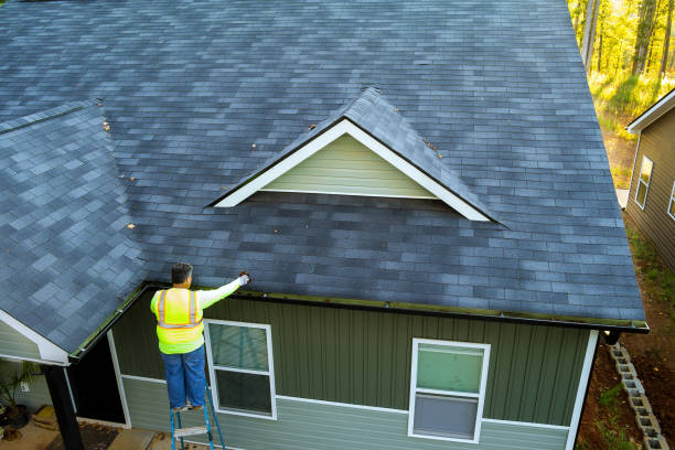 istock Using a ladder, worker cleans debris, dirt, fallen leaves from clogged roof gutter drain 1810479809