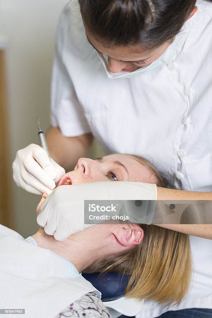 Dentista feminina trabalhando com paciente dentistas mulher na cadeira - Foto de stock de Adulto royalty-free