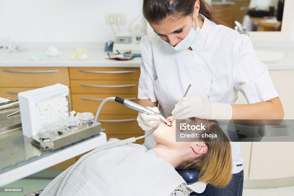 Женский Стоматолог на работе с женщина пациента на стоматологов стул - Стоковые фото Взаимодействие роялти-фри