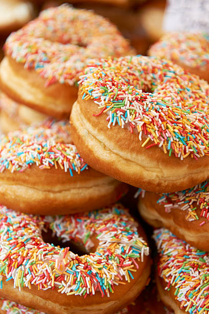 istock Pile Of Sprinkle Covered Donuts On Market Stall 181048722