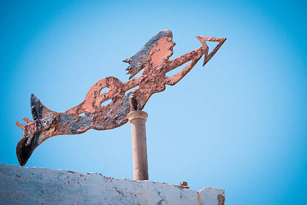 Mermaid weathervane with an orange sunset. Photographed in Beaufort, North Carolina.