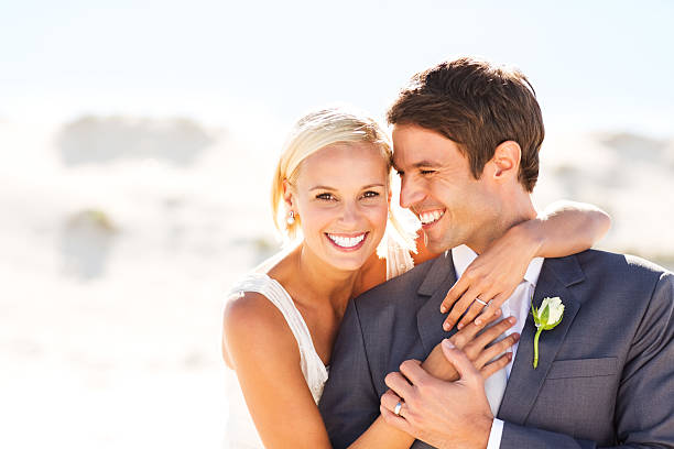istock Beautiful Bride Embracing Groom From Behind On Beach 181048919