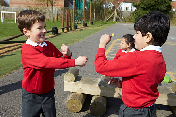 Two Boys Fighting In School Playground Two Elementary Pupils Fighting In School Playground schoolyard fight stock pictures, royalty-free photos & images