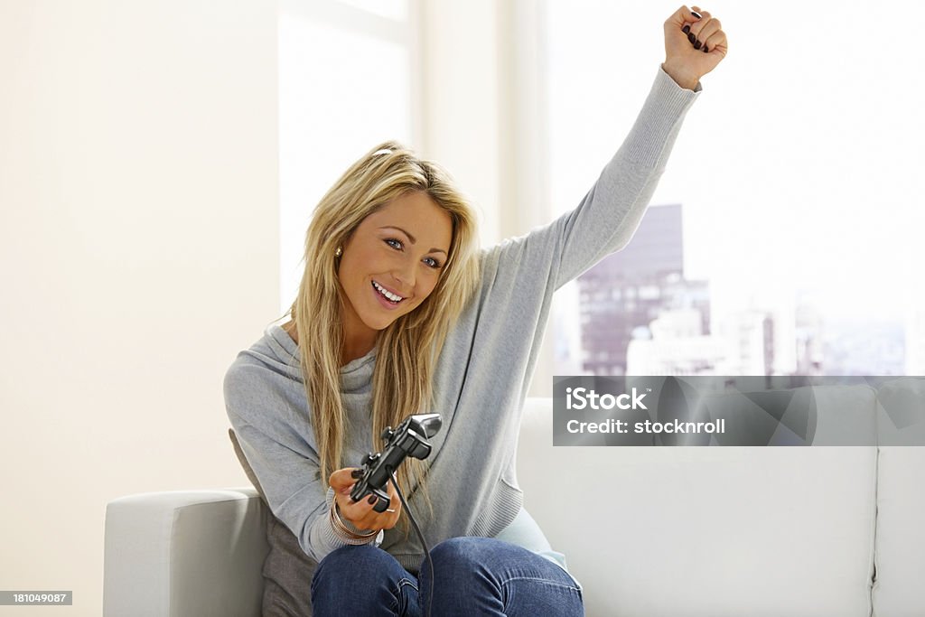 Bella giovane ragazza che si diverte a giocare videogiochi - Foto stock royalty-free di Console - Attrezzatura elettronica