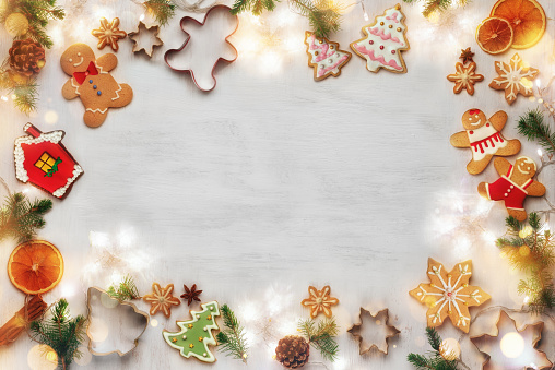 Mockup with festive food decorations, garland with lights and gingerbread cookies on white background.