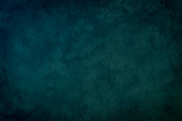Horizontal full frame studio shot of dark blue dyed muslin backdrop with slight dark vignette.